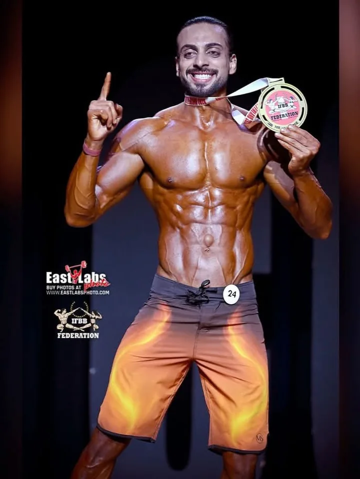 Ellipse Fitness Club athlete on stage in Switzerland with his IFBB medal